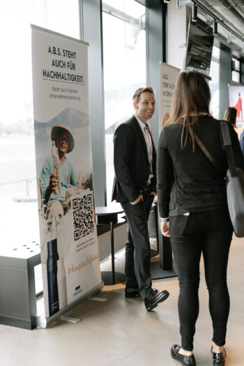 Mann und Frau in Businesskleidung neben Rollup